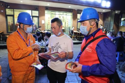 為各個(gè)攤位檢查用電安全情況、排查隱患、發(fā)放用電安全宣傳單